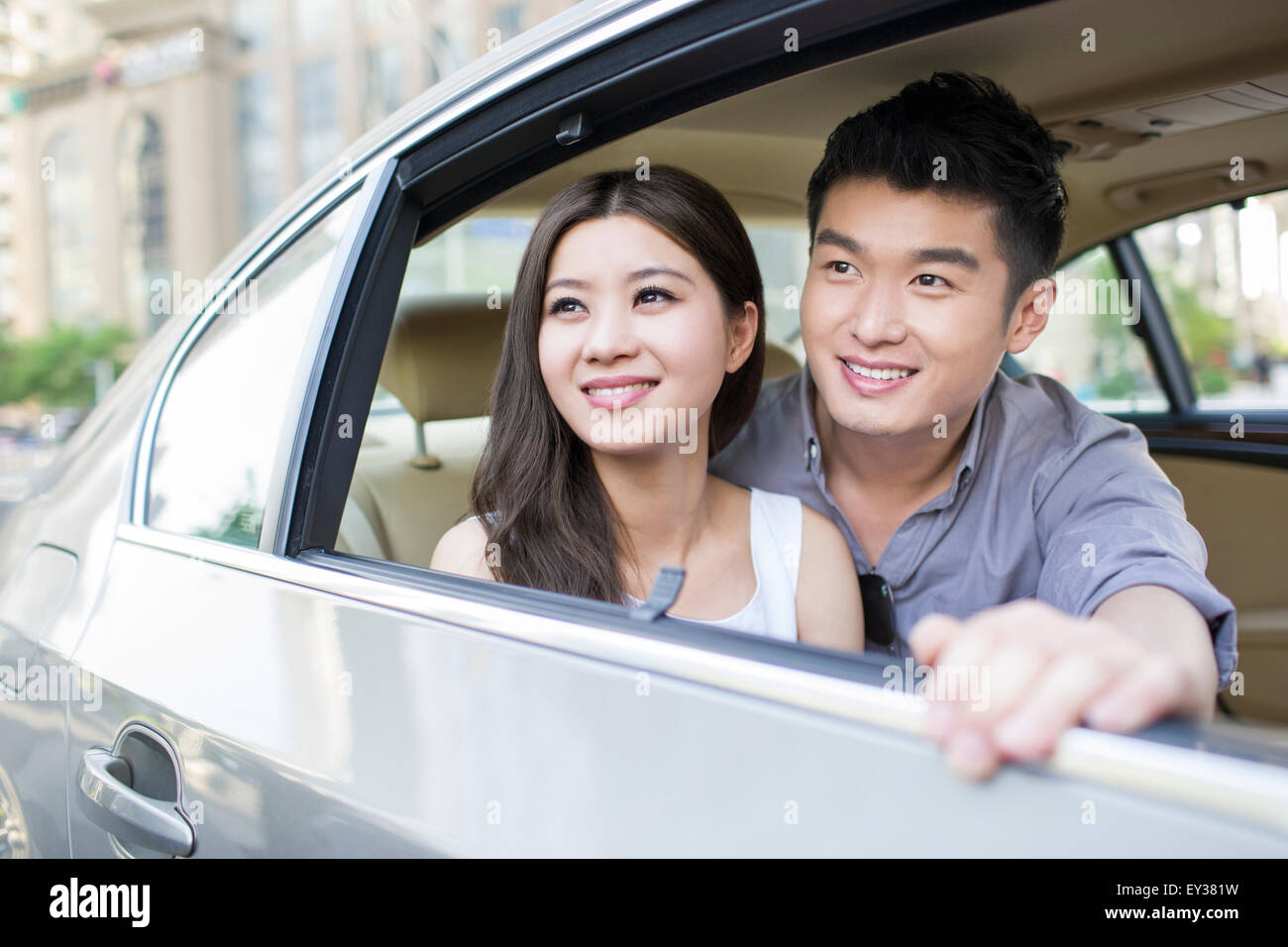 Happy young couple in a car Stock Photo - Alamy