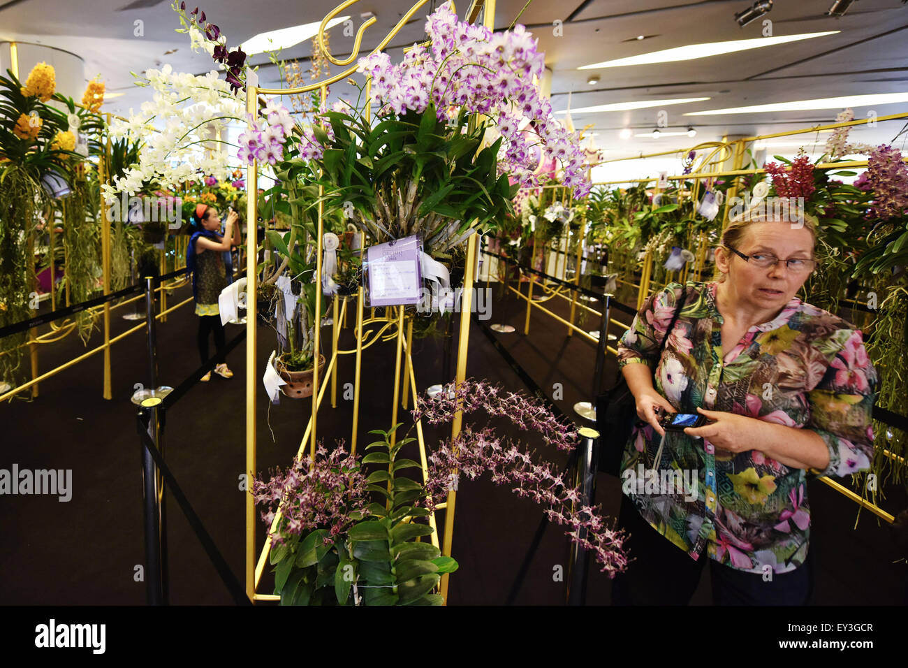 Bangkok, Thailand. 21st July, 2015. A woman visits the 9th Siam Paragon Bangkok Royal Orchid Paradise in Bangkok, Thailand, July 21, 2015. More than 120 types of orchids from all over Thailand were put on show as the 9th Siam Paragon Bangkok Royal Orchid Paradise kicked off Tuesday in Bangkok. © Li Mangmang/Xinhua/Alamy Live News Stock Photo