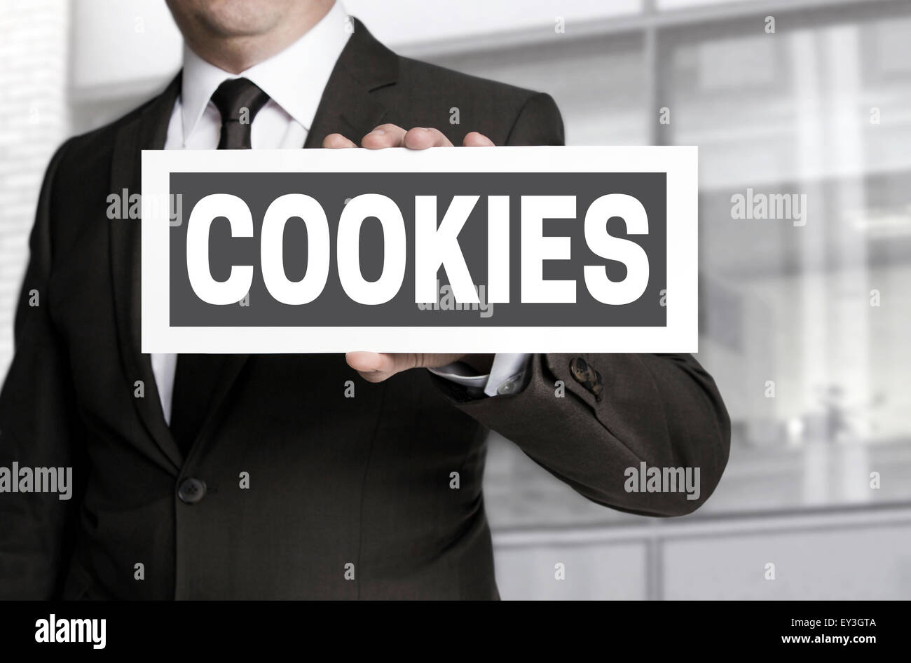 Cookies plate is held by businessman background. Stock Photo