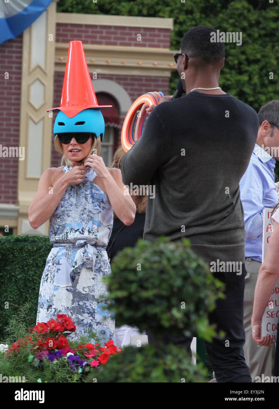 Kelly Ripa plays a ring toss game with a construction cone on her head ...