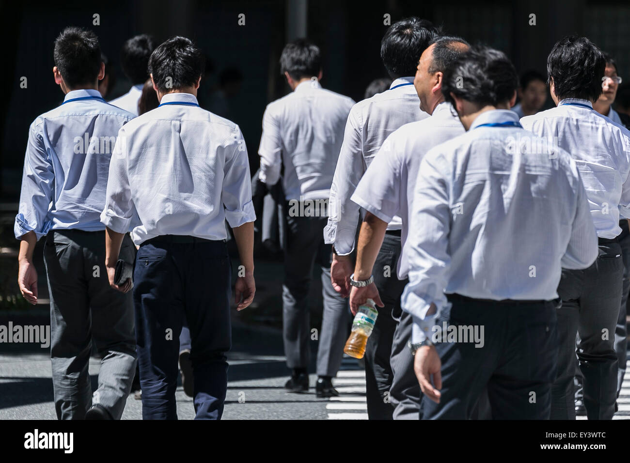 Tokyo, Japan. 21st July, 2015. Japanese office workers walk under the hot  sunshine in Shinjuku district on July 21, 2015, Tokyo, Japan. The Japan  Meteorological Agency announced on Sunday that they believe