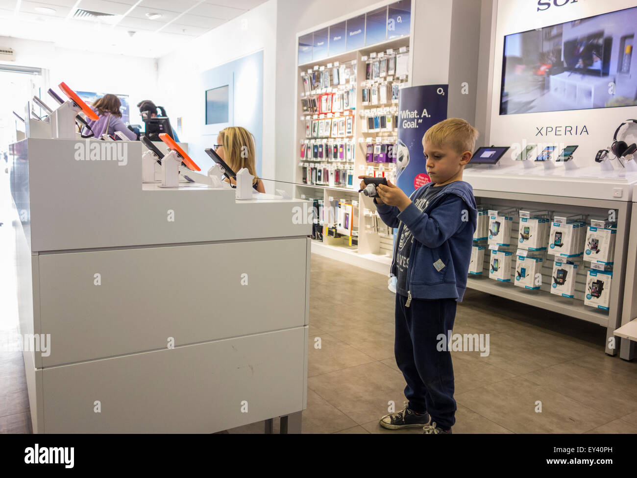 boy playing with camera in O2 store, Canterbury, England Stock Photo