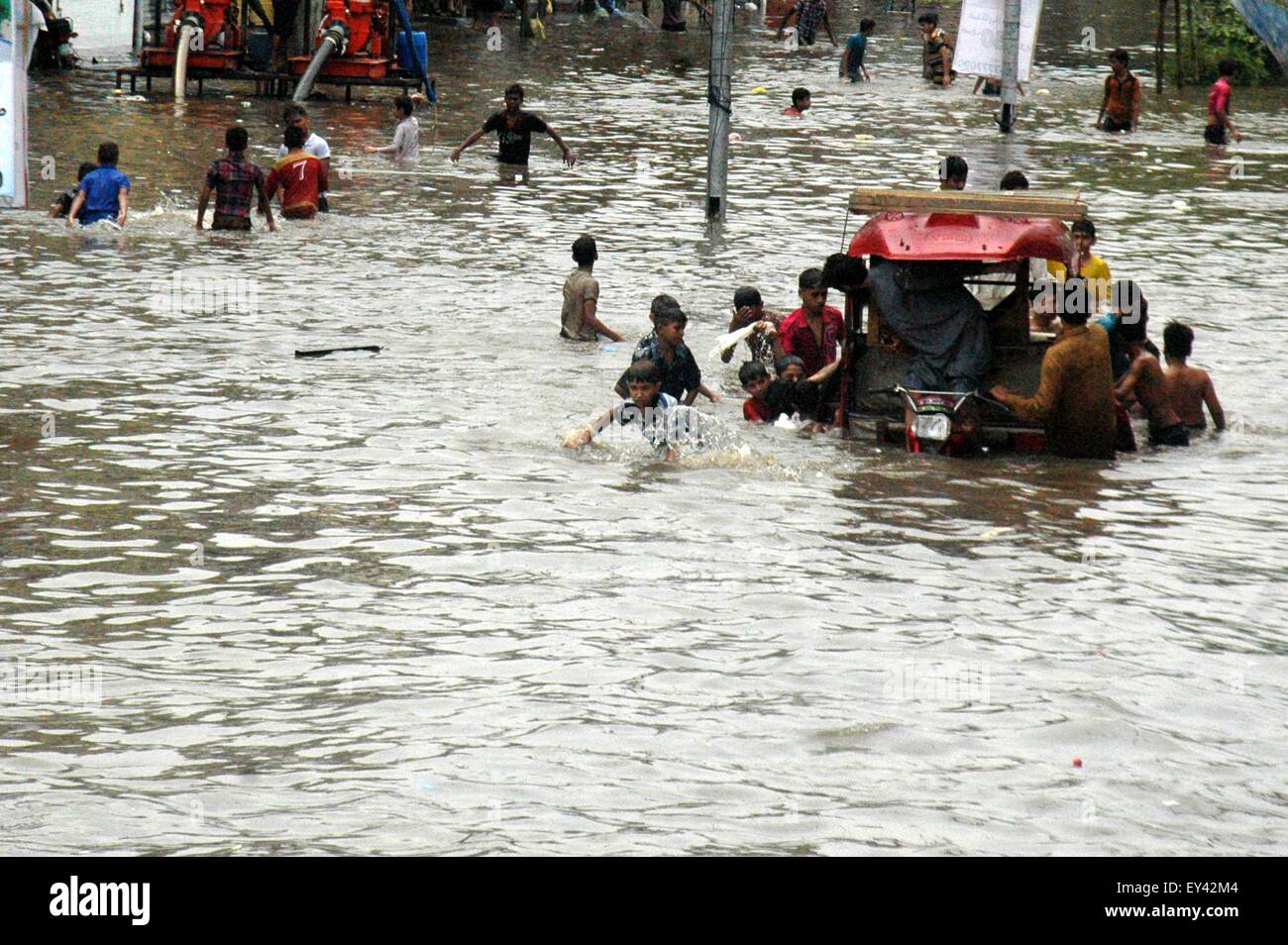 Lahore. 21st July, 2015. Pakistani boys push an autorickshaw in a