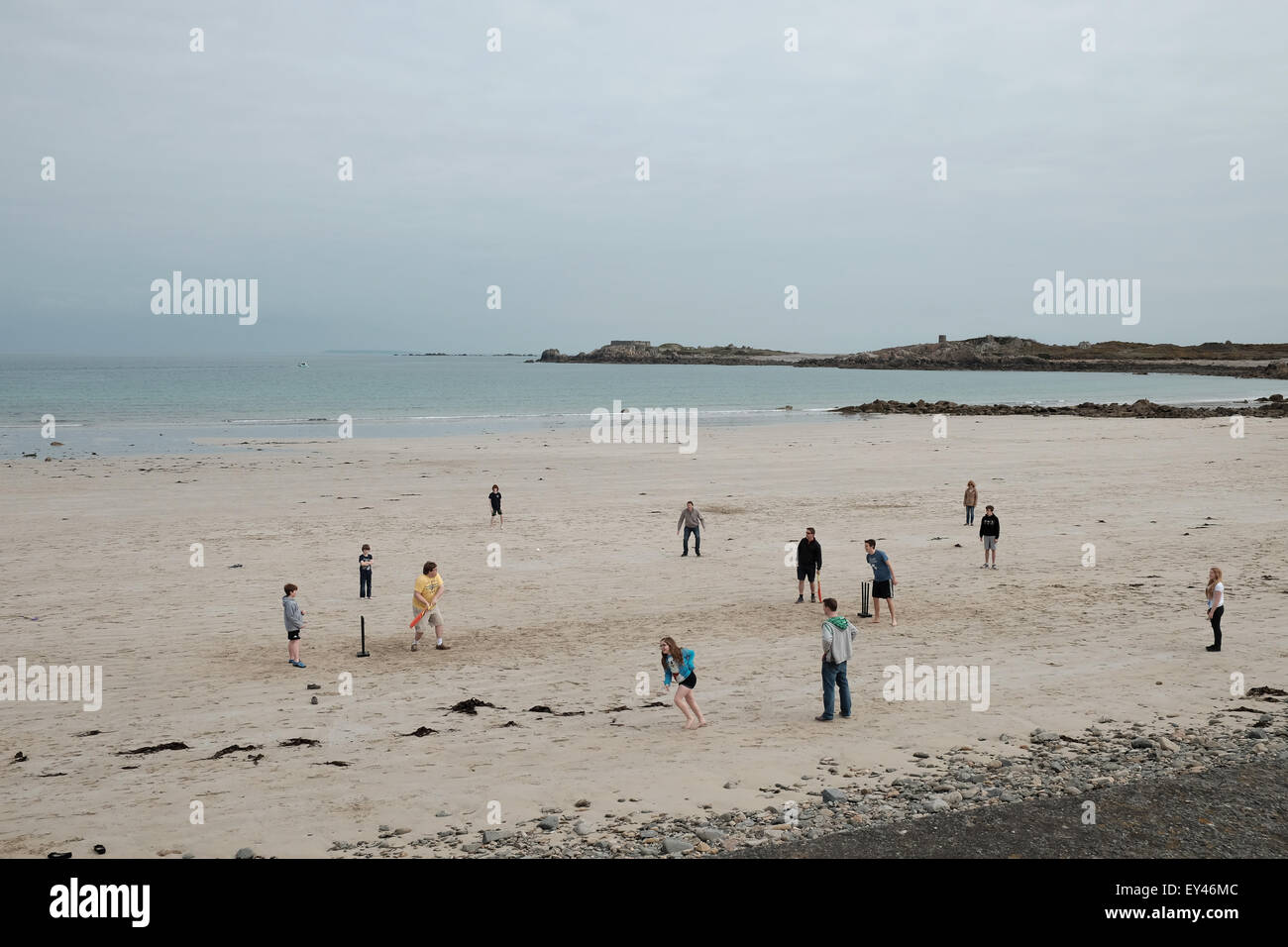 Community playing on cricket a sandy beach Stock Photo