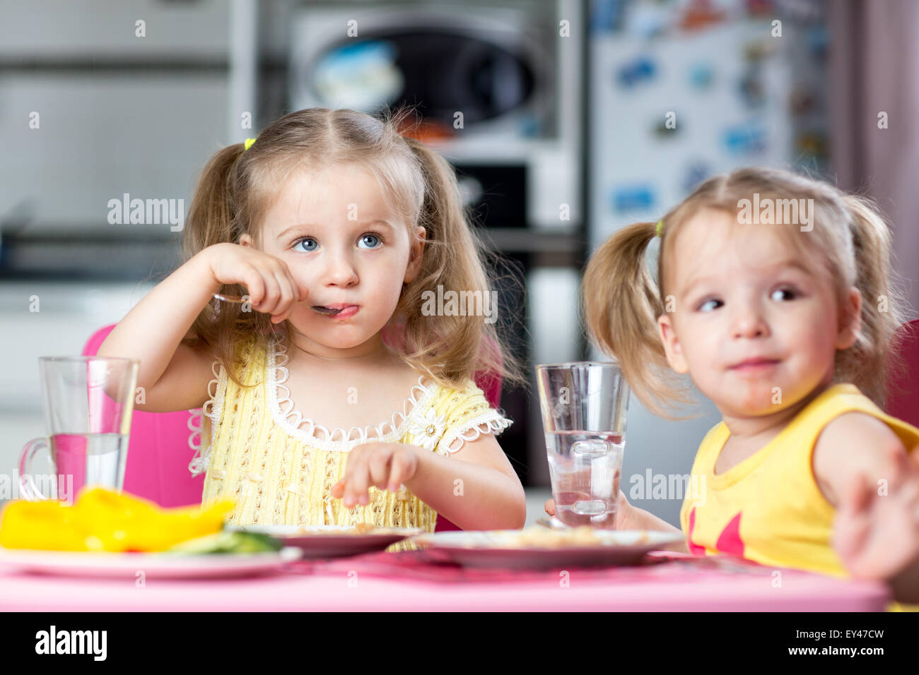 Children drinking and eating at daycare Stock Photo