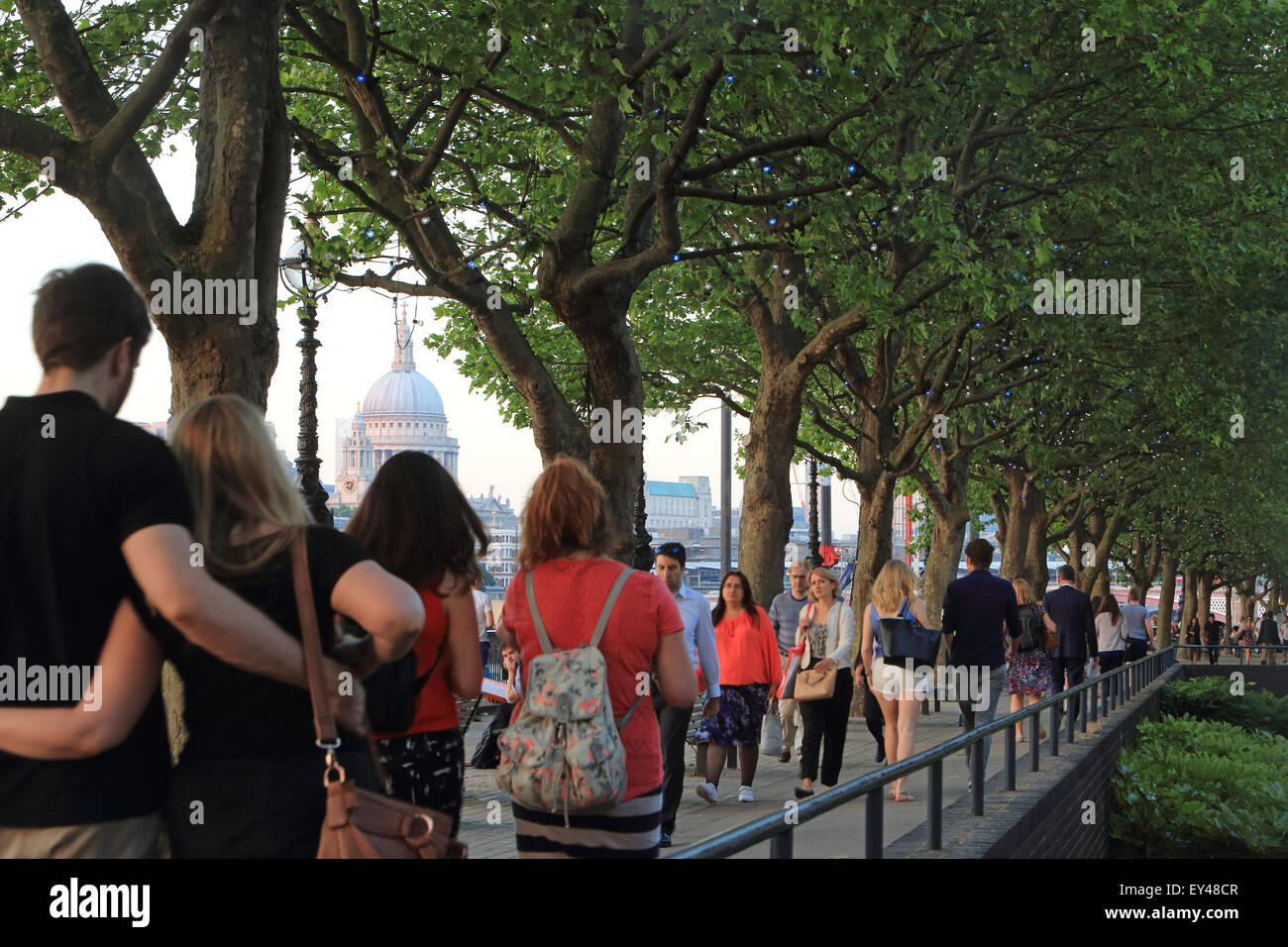 People strolling along the South Bank on a warm summer's evening, St Paul's Cathedral behind, in London, UK Stock Photo