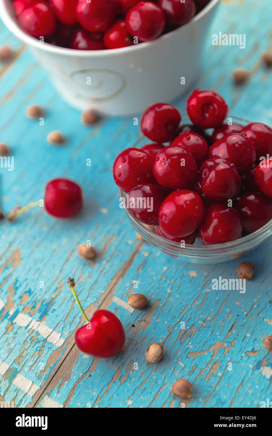 Cherries in Bowl on Rustic Table, Ripe Fresh Fruit and Cherry Pits as ...
