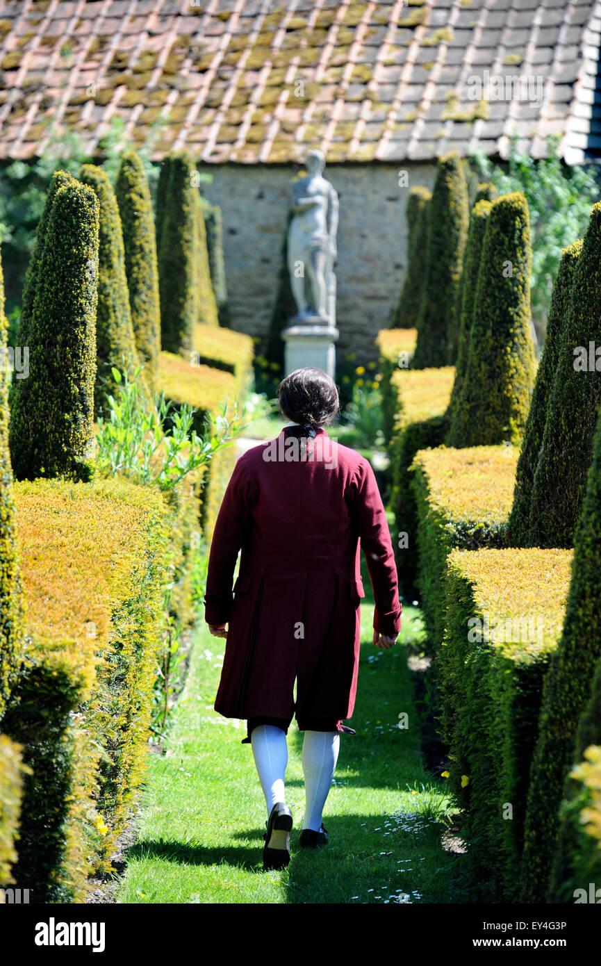 An opera singer strolls through the parterre garden at Garsington Manor, Oxfordshire UK Stock Photo