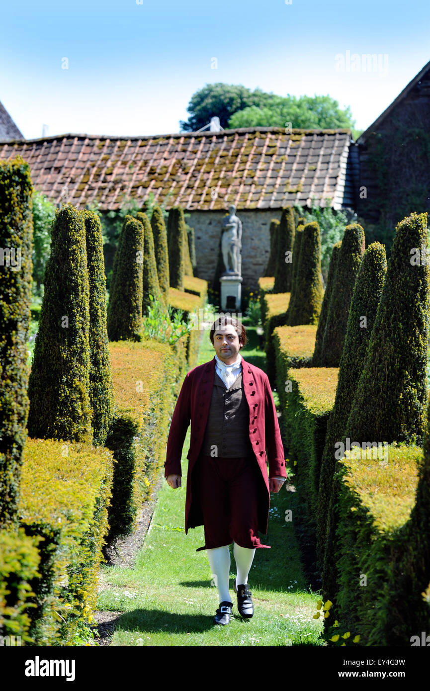 An opera singer strolls through the parterre garden at Garsington Manor, Oxfordshire UK Stock Photo