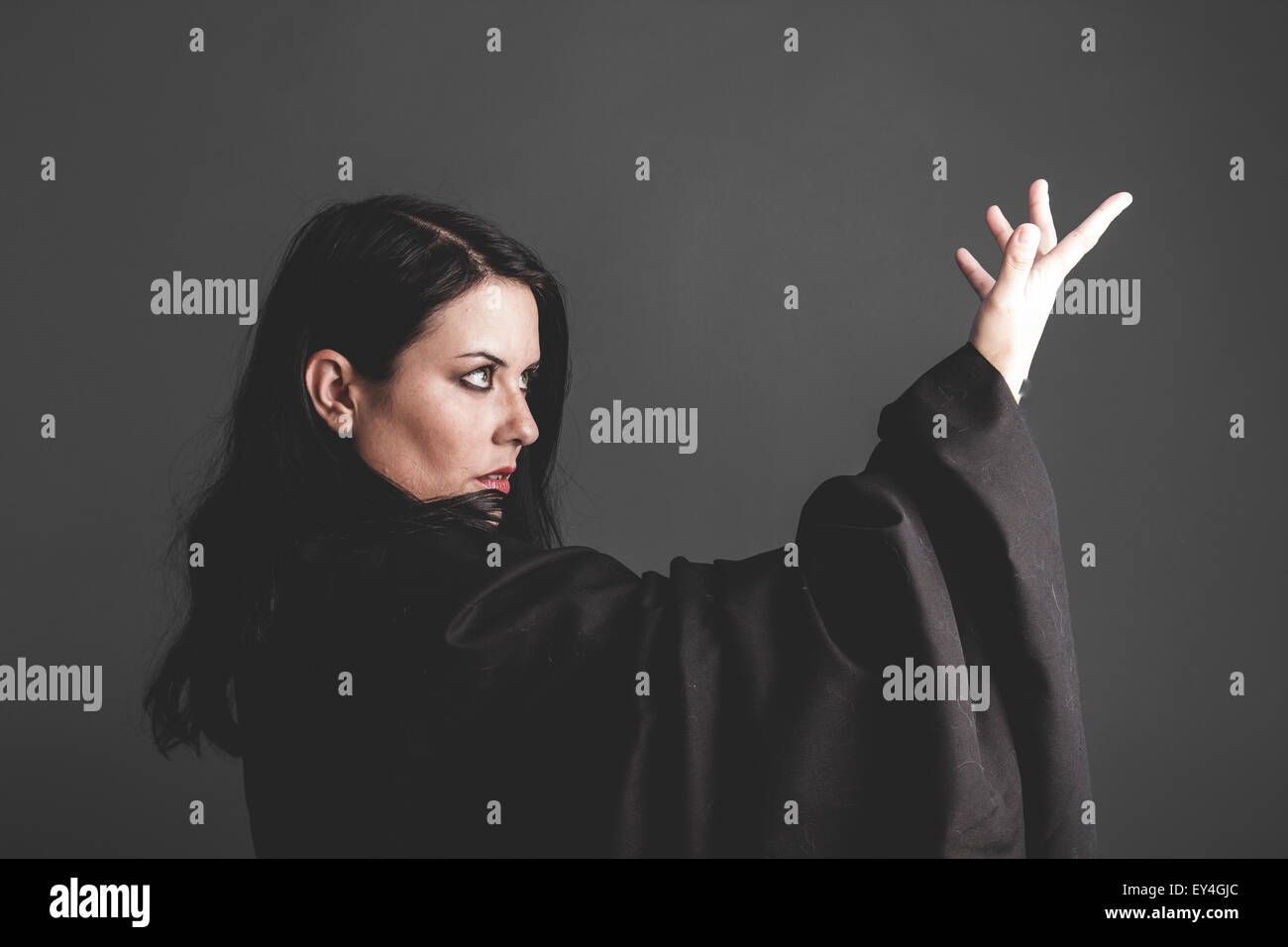 Gothic Dark Woman With Large Black Cloth On Gray Background Sadness