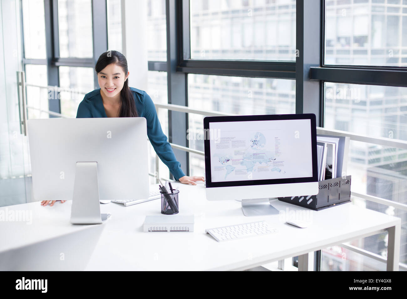 Young businesswoman using computer in office Stock Photo - Alamy