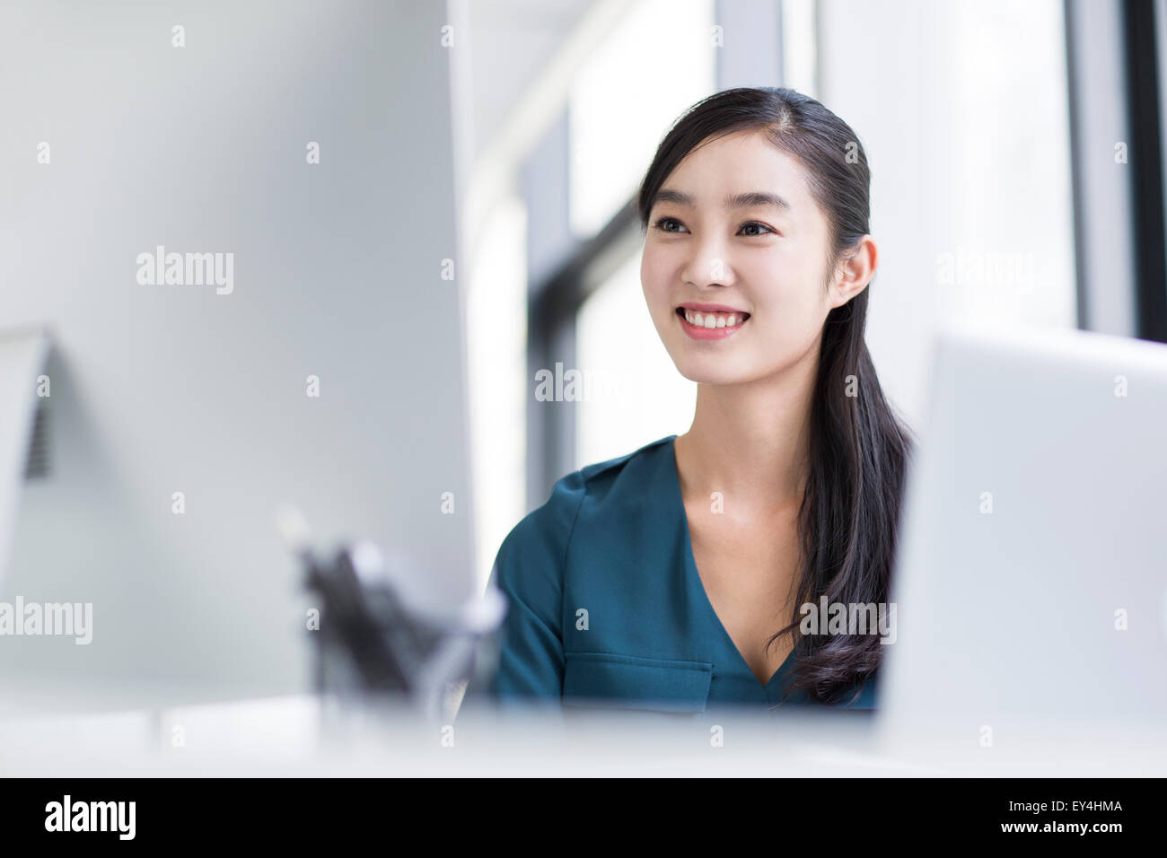 Young businesswoman using computer in office Stock Photo - Alamy