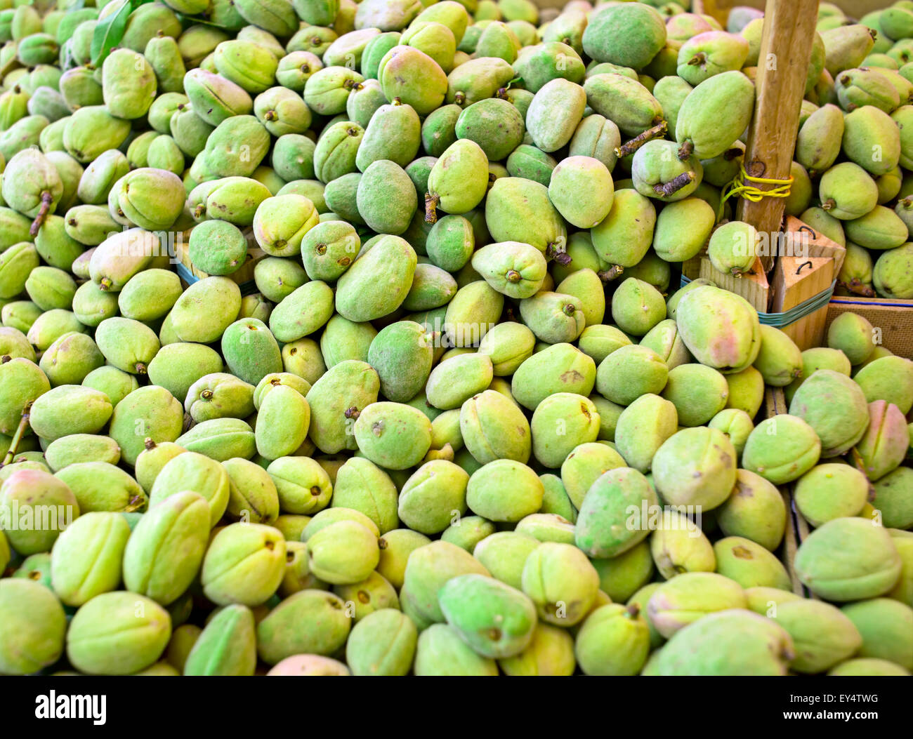 Fresh green almonds with shell in a market. Stock Photo