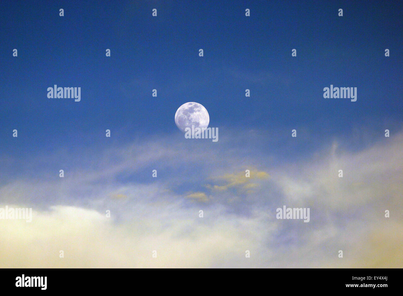 Moon During Spring Moon rising above the clouds during a spring afternoon Stock Photo - Alamy