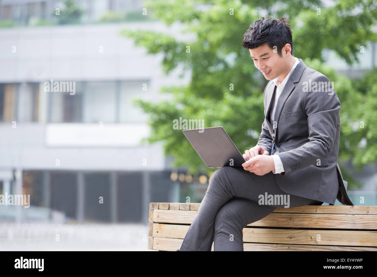 Young businessman working with laptop outdoors Stock Photo - Alamy