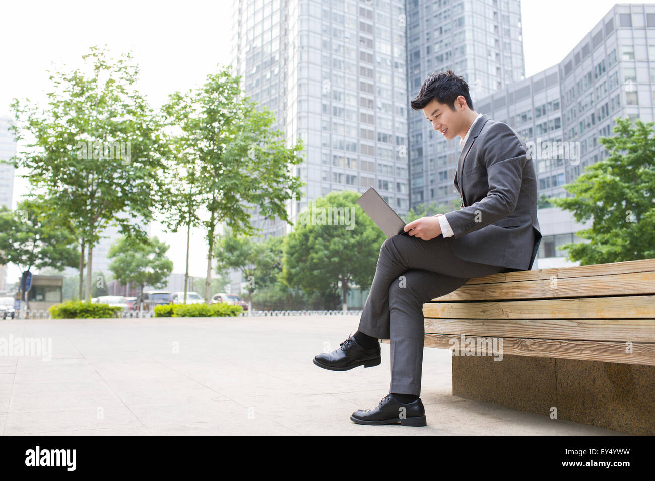 Young businessman working with laptop outdoors Stock Photo - Alamy