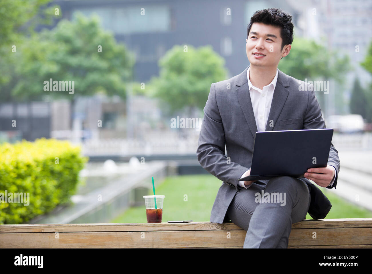Young businessman working with laptop outdoors Stock Photo - Alamy