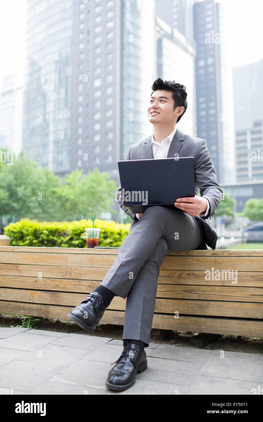 Young businessman working with laptop outdoors Stock Photo - Alamy
