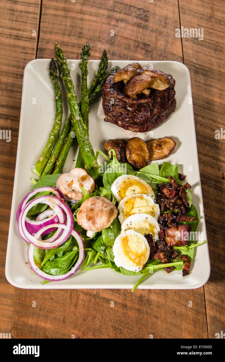 Plated dinner of steak and spinach salad Stock Photo