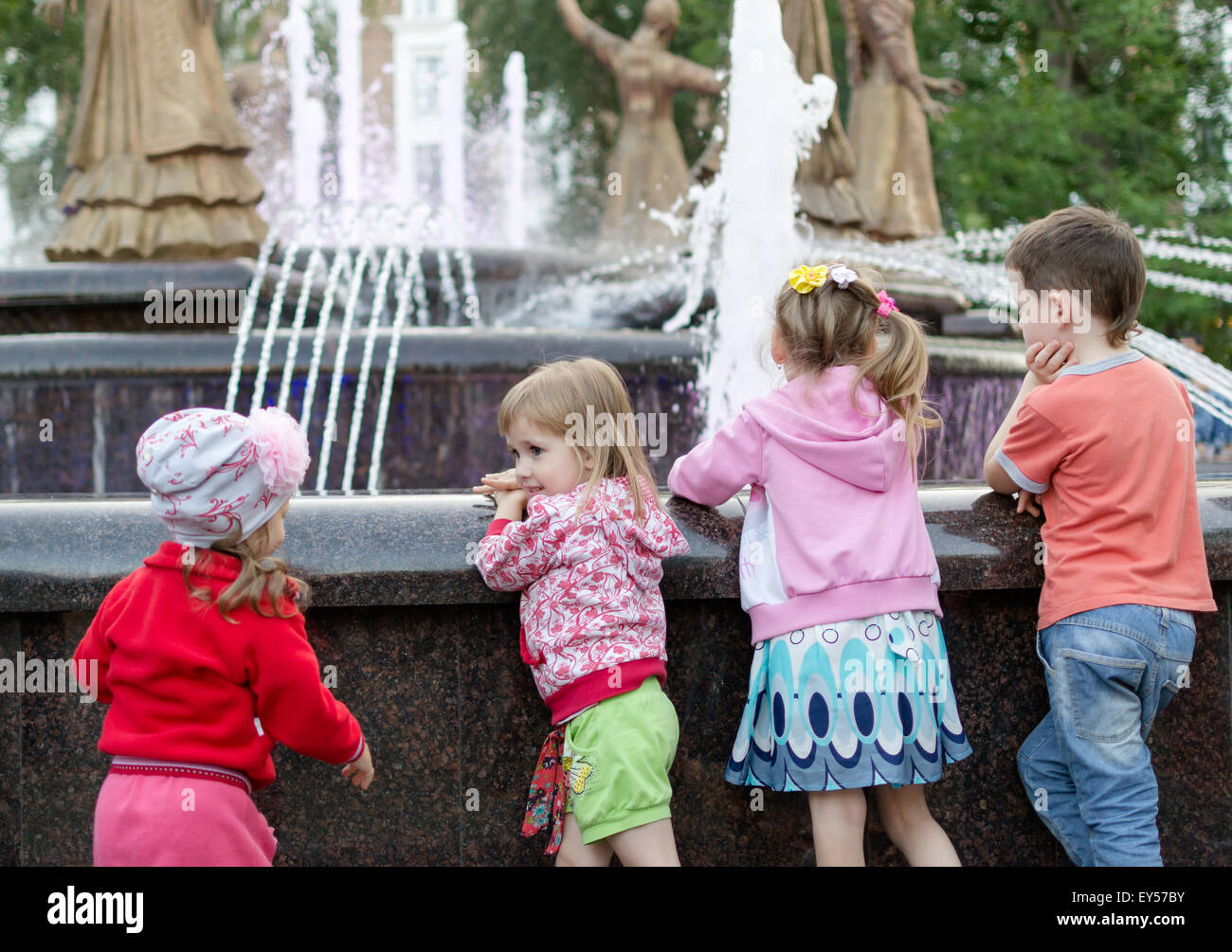 Four children happpily watch a fountain display in Ufa Russia in July 2015 Stock Photo