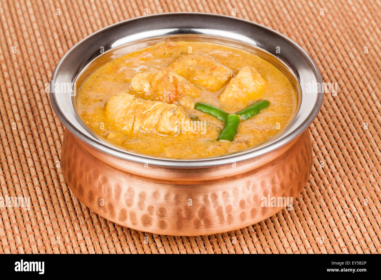 Indian chicken curry served in authentic copper bowl. Green chilli used