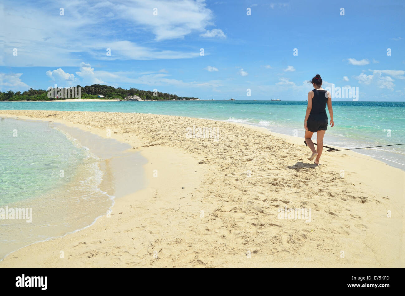 Girl walking on a sandbar in Belitung Stock Photo
