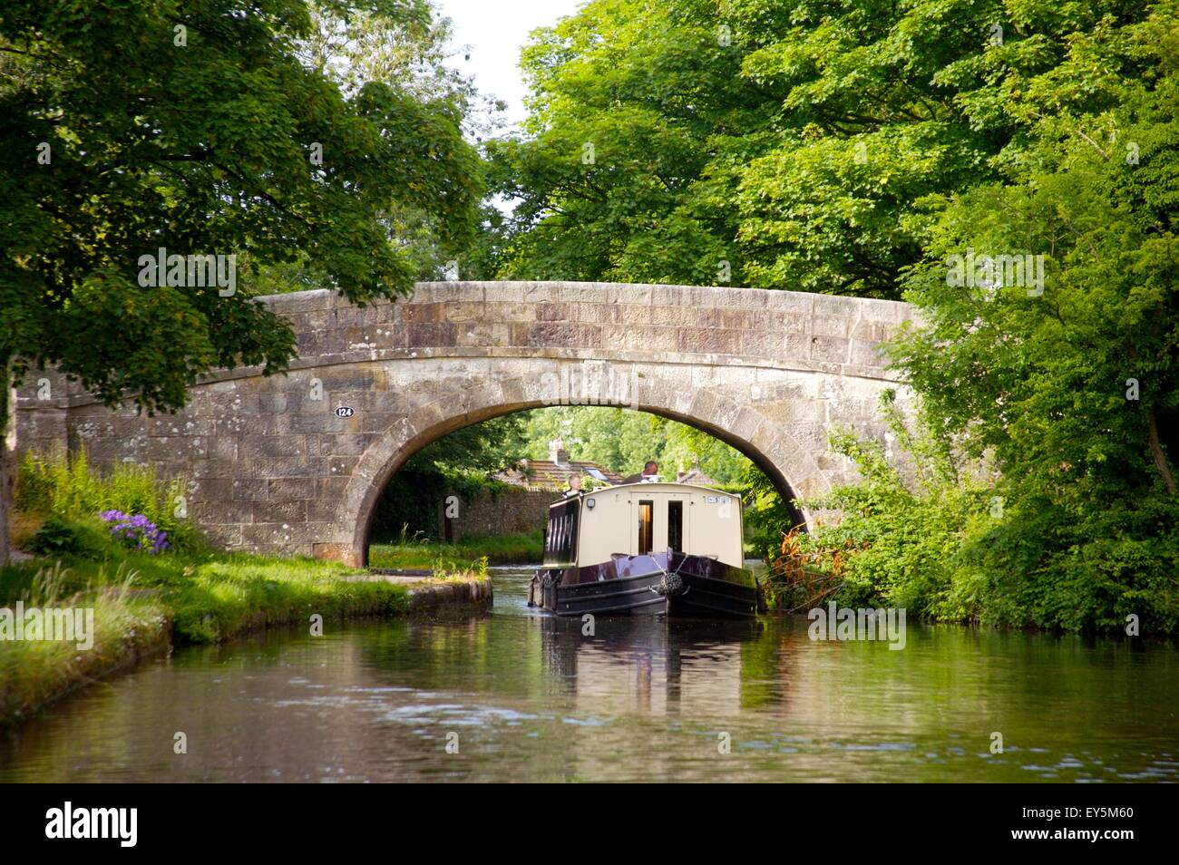 narrowboat passing under bridge on Lancaster Canal, near Bolton Le Sands, Lancashire Stock Photo