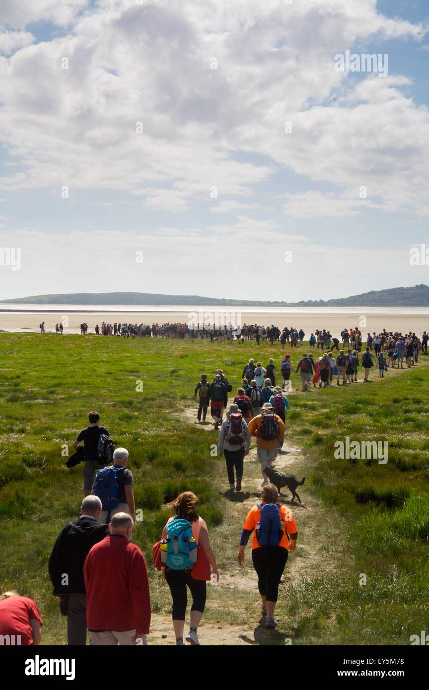 walkers heading to Morecambe bay to cross the sands at low tide guided by the Queen's guide to the sands. Stock Photo