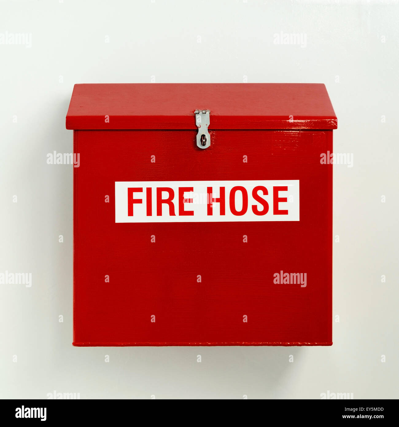 Fire hose box in bright red hung on white wall Stock Photo