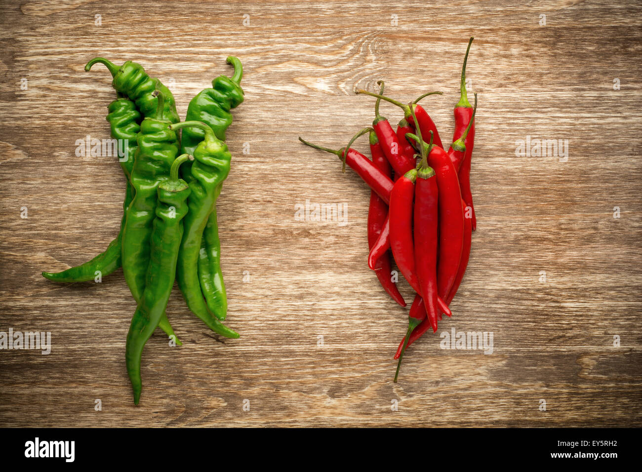 Red and green chili peppers on wooden background Stock Photo - Alamy