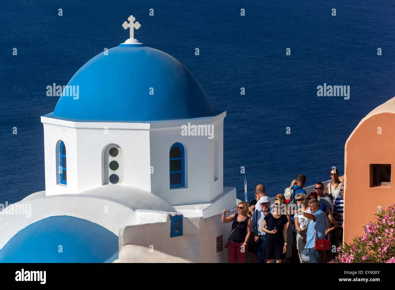 People, Tourists in Oia village street at blue dome church, Santorini, Cyclades Islands, Greek Islands, Greece, Europe Stock Photo