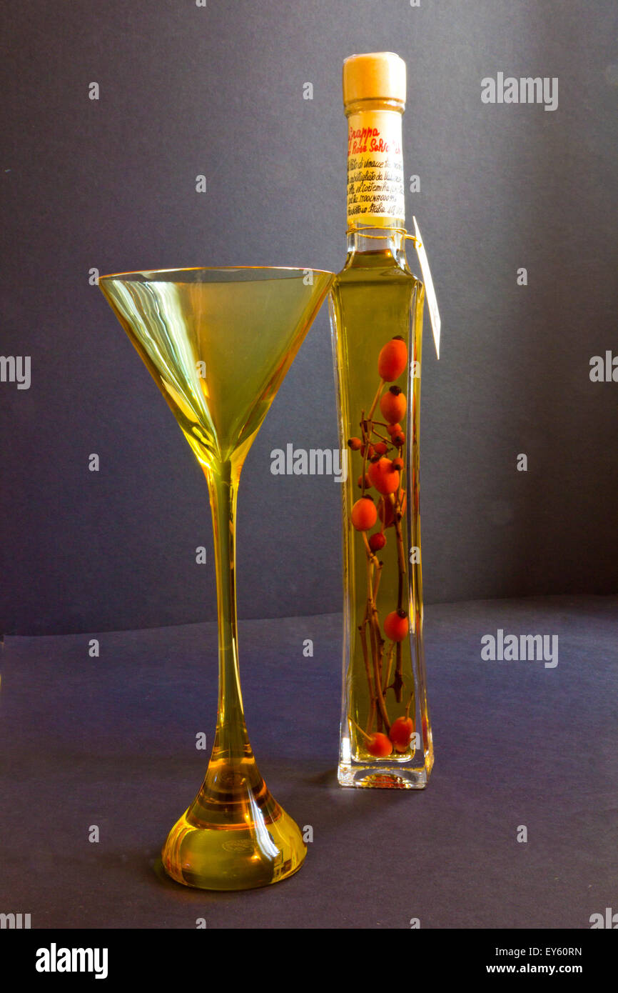 Grappa Rose Wine with Rose-hips in bottle with Tasting Glass Stock Photo