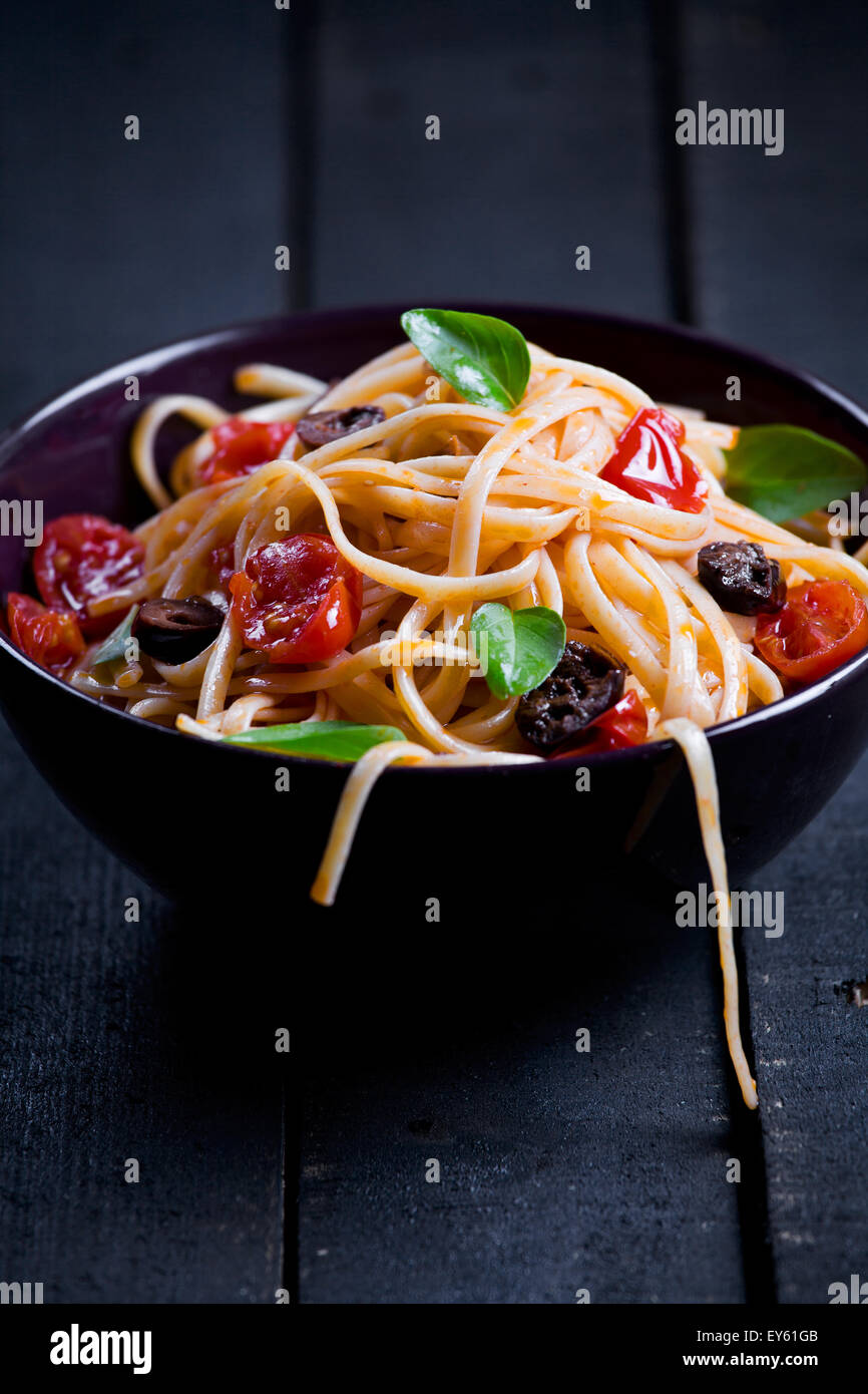 Close up of some pasta with tomatoes olives and basil Stock Photo