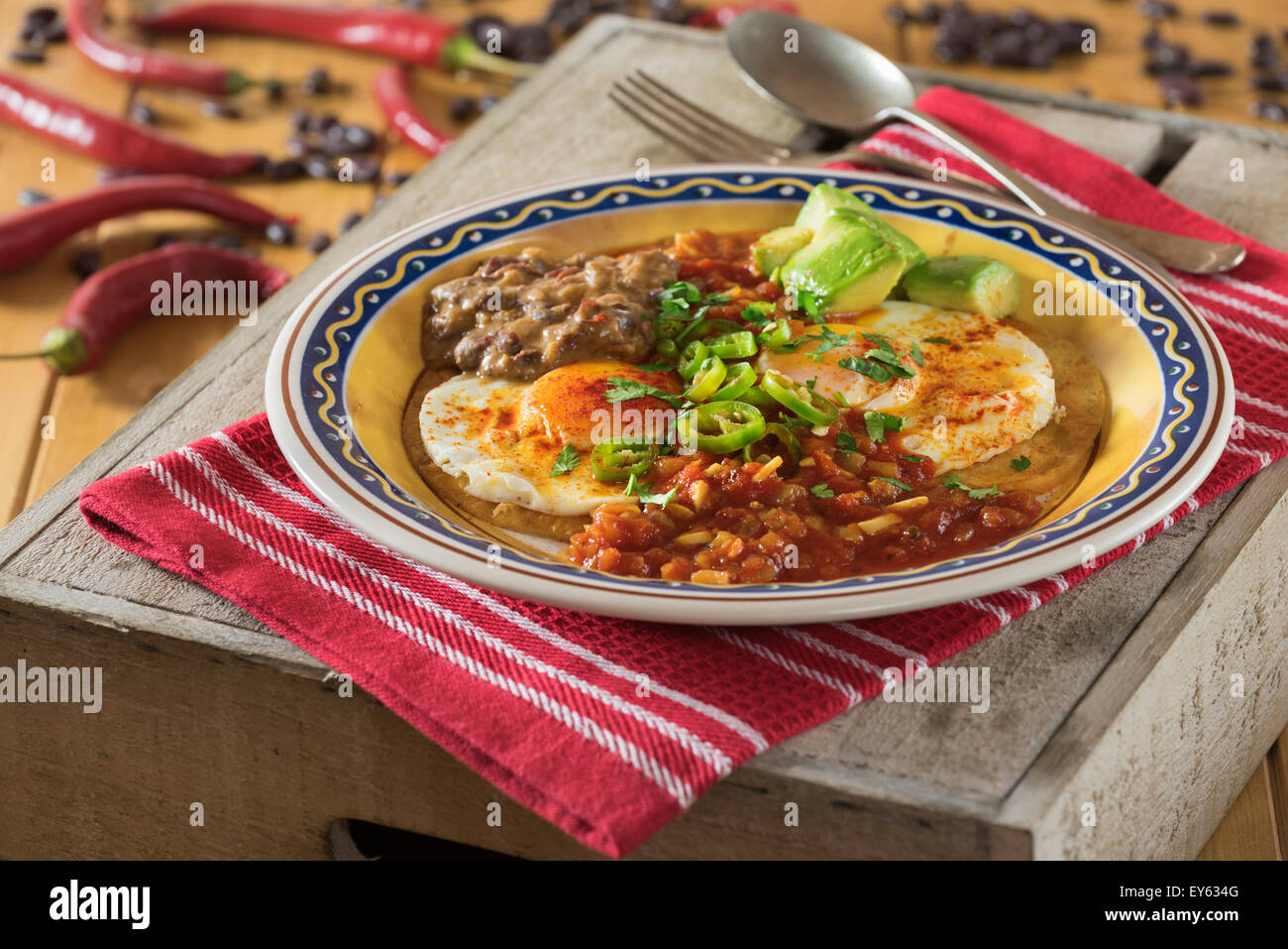 Huevos rancheros. Fried eggs on tortillas with tomato chilli sauce and refried beans Stock Photo