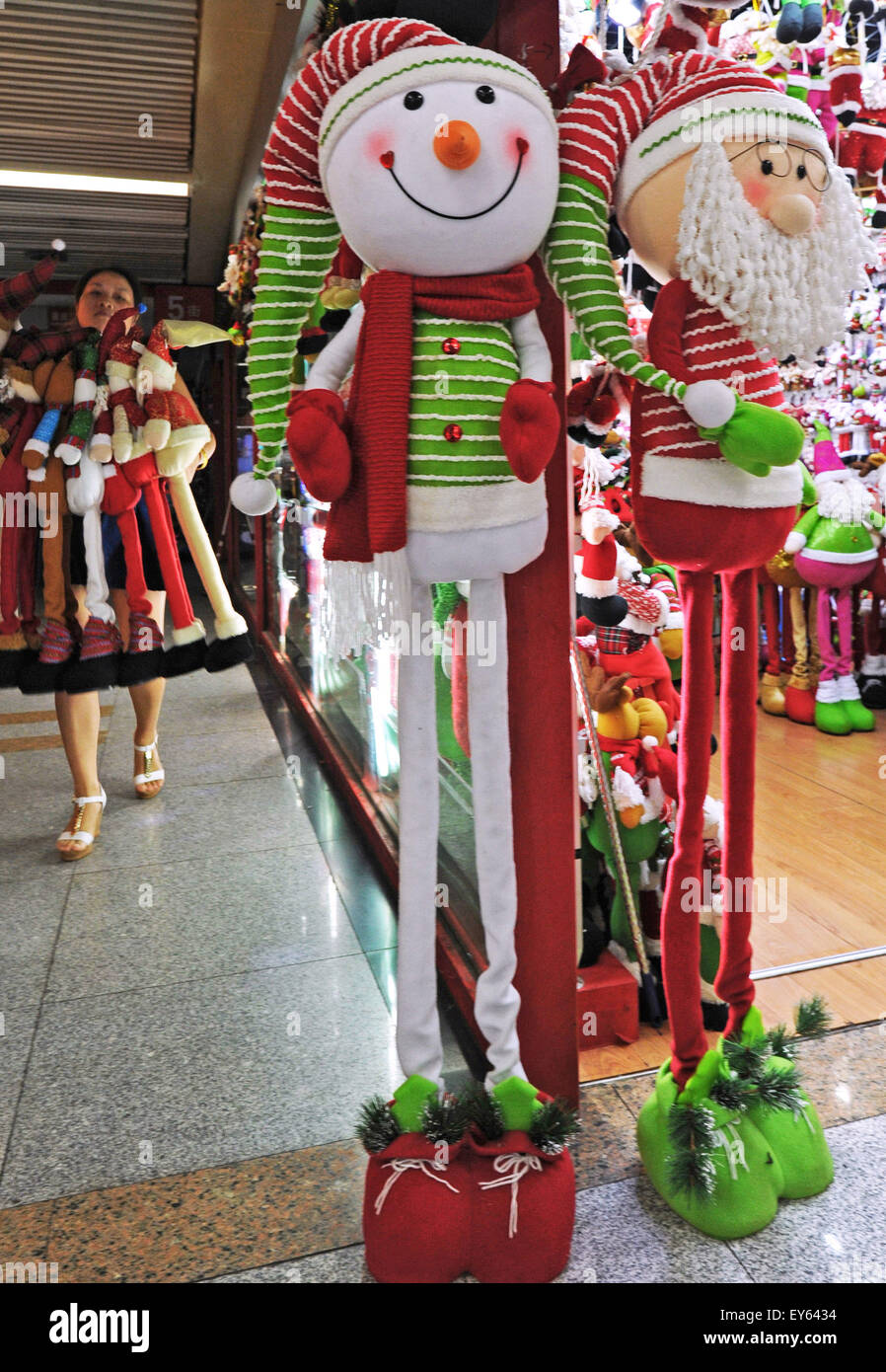 Yiwu, China's Zhejiang Province. 19th July, 2015. A businesswoman carries newly designed extensible Santa Claus dolls at Yiwu International Trading Mall, east China's Zhejiang Province, July 19, 2015. Known as the worldwide largest trading hub of Christmas commodity, Yiwu has come to its peak season of production and sale since July. © Tan Jin/Xinhua/Alamy Live News Stock Photo