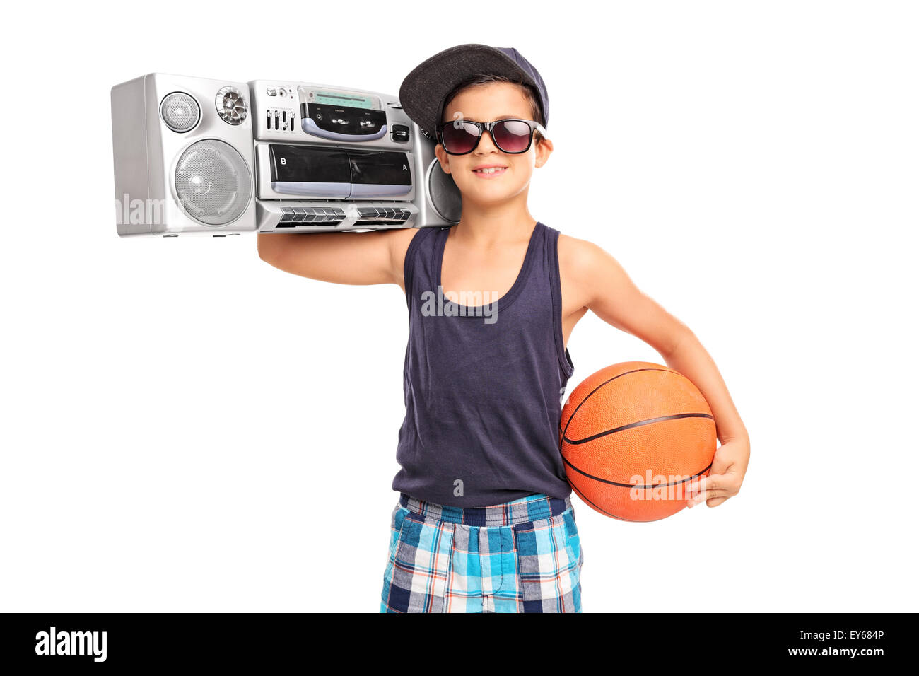 Studio shot of a little boy holding a basketball and a ghetto blaster isolated on white background Stock Photo