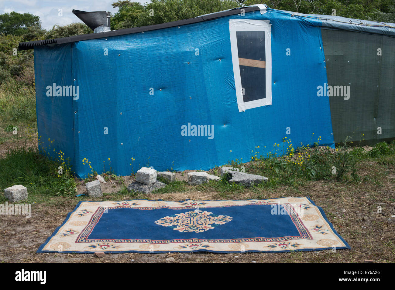 Calais, France. 22nd July, 2015. Refugees from Afghanistan, Syria, Sudan, and Eritrea steadily descend on a migrant camp in the French coastal town of Calais. They hope to gain entry to the UK, just 21 miles away across the English Channel. But in May, French police destroyed their camp and told the migrants to go elsewhere. And so they moved. across the street. (Credit Image: © Velar Grant via ZUMA Wire) Credit:  ZUMA Press, Inc./Alamy Live News Stock Photo