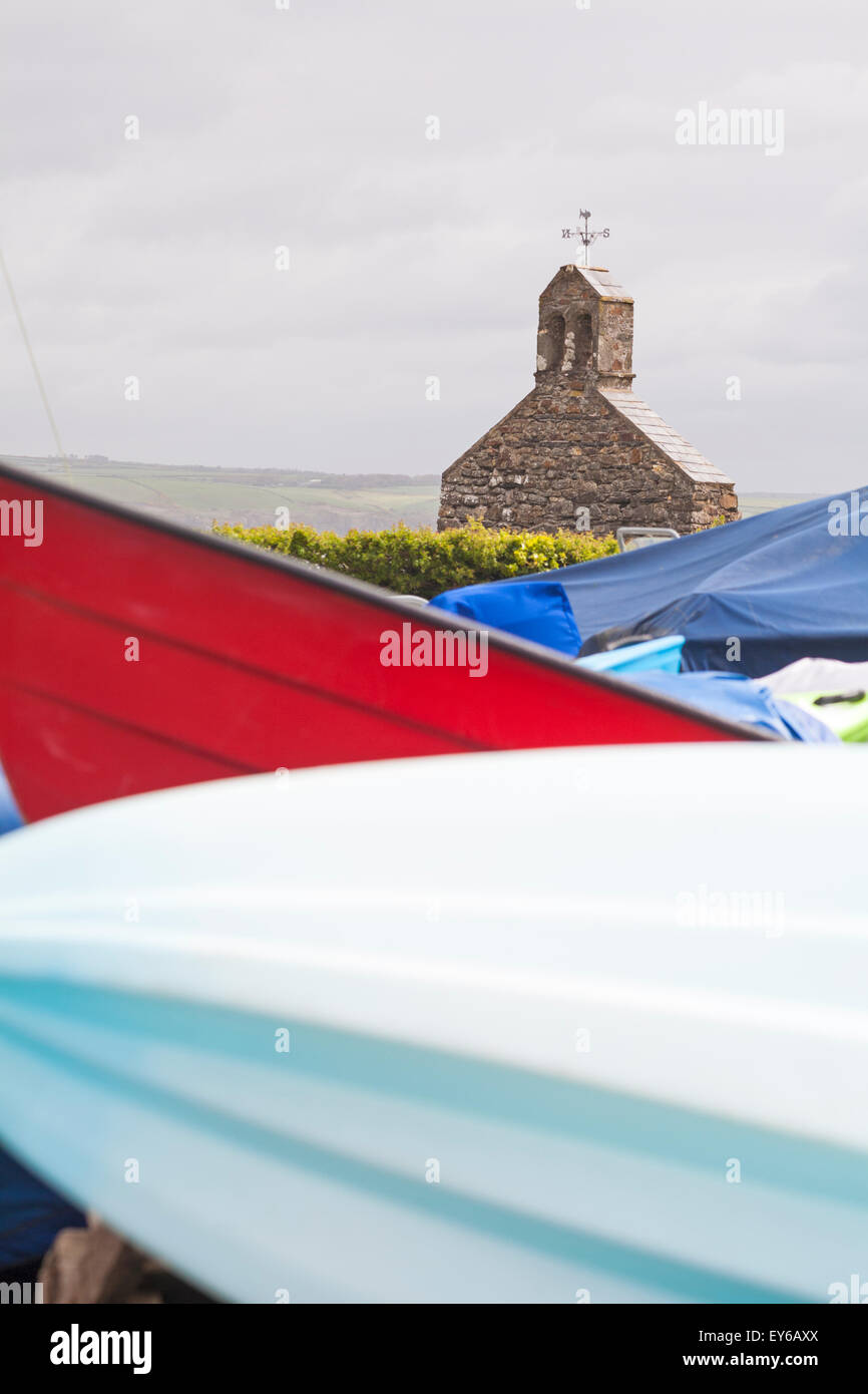 remains of church seen with shapes of boats in the foreground at Cwm yr Eglwys, Pembrokeshire Coast National Park, Wales UK in May Stock Photo