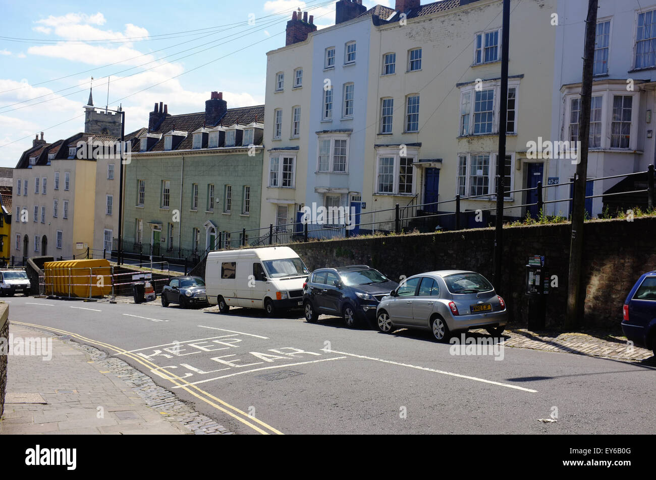 Vehicles parked beneath a row of houses along St Michael's Hill near