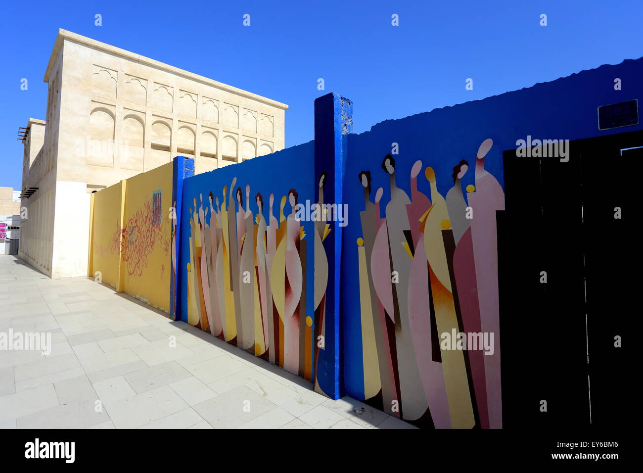 An alley in old Muharraq, with modern artwork on a wall, on the Pearl Trail, Kingdom of Bahrain Stock Photo