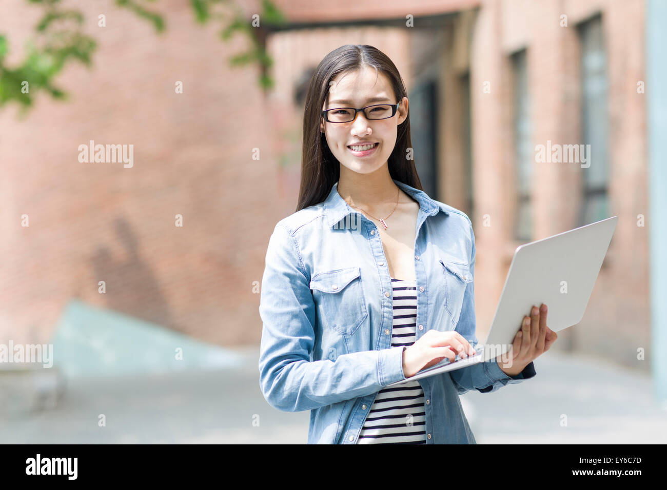 Young woman holding a laptop Stock Photo - Alamy