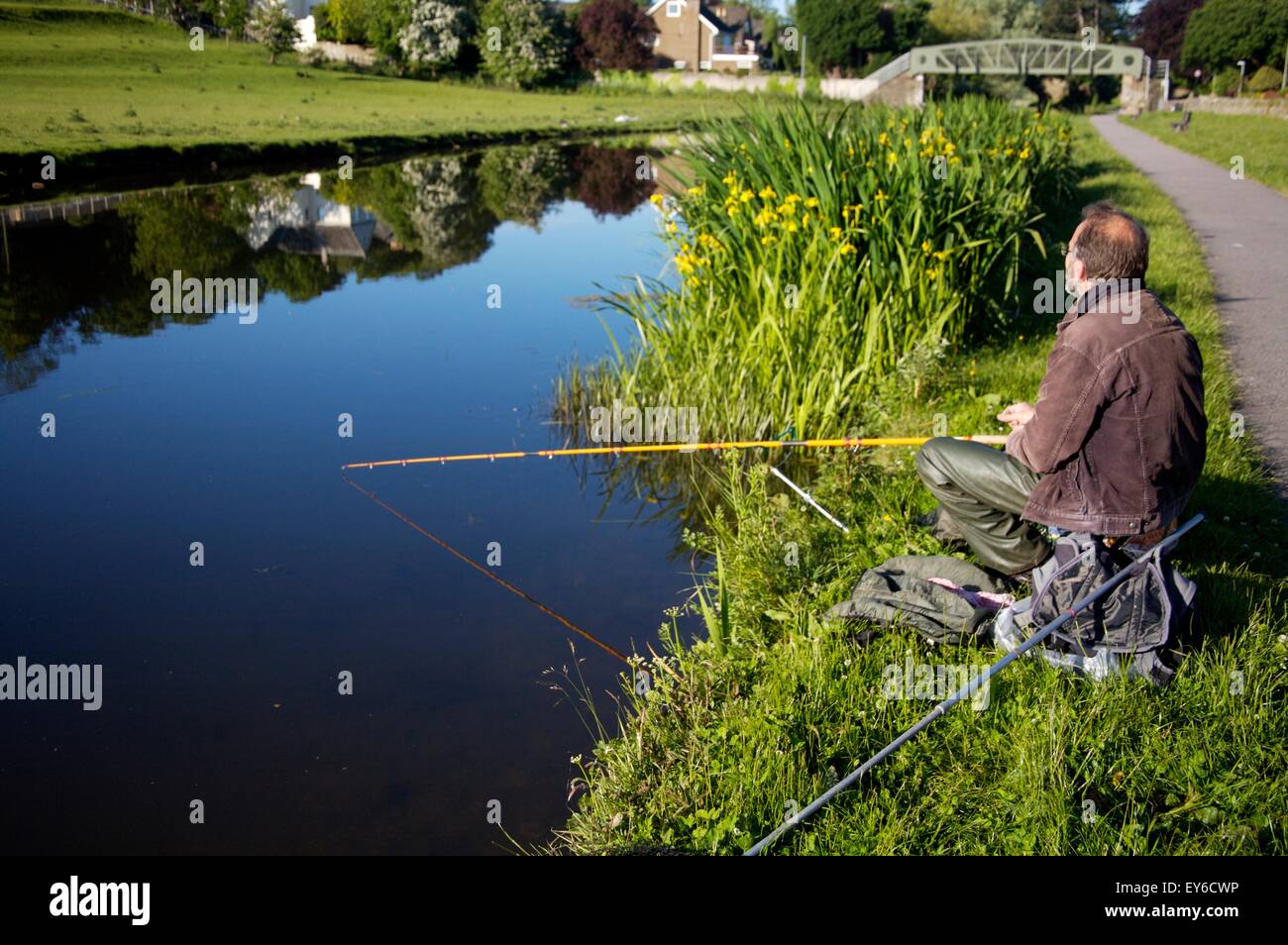 Man fishing on the Lancaster Canal in Lancaster, Lancashire Stock Photo