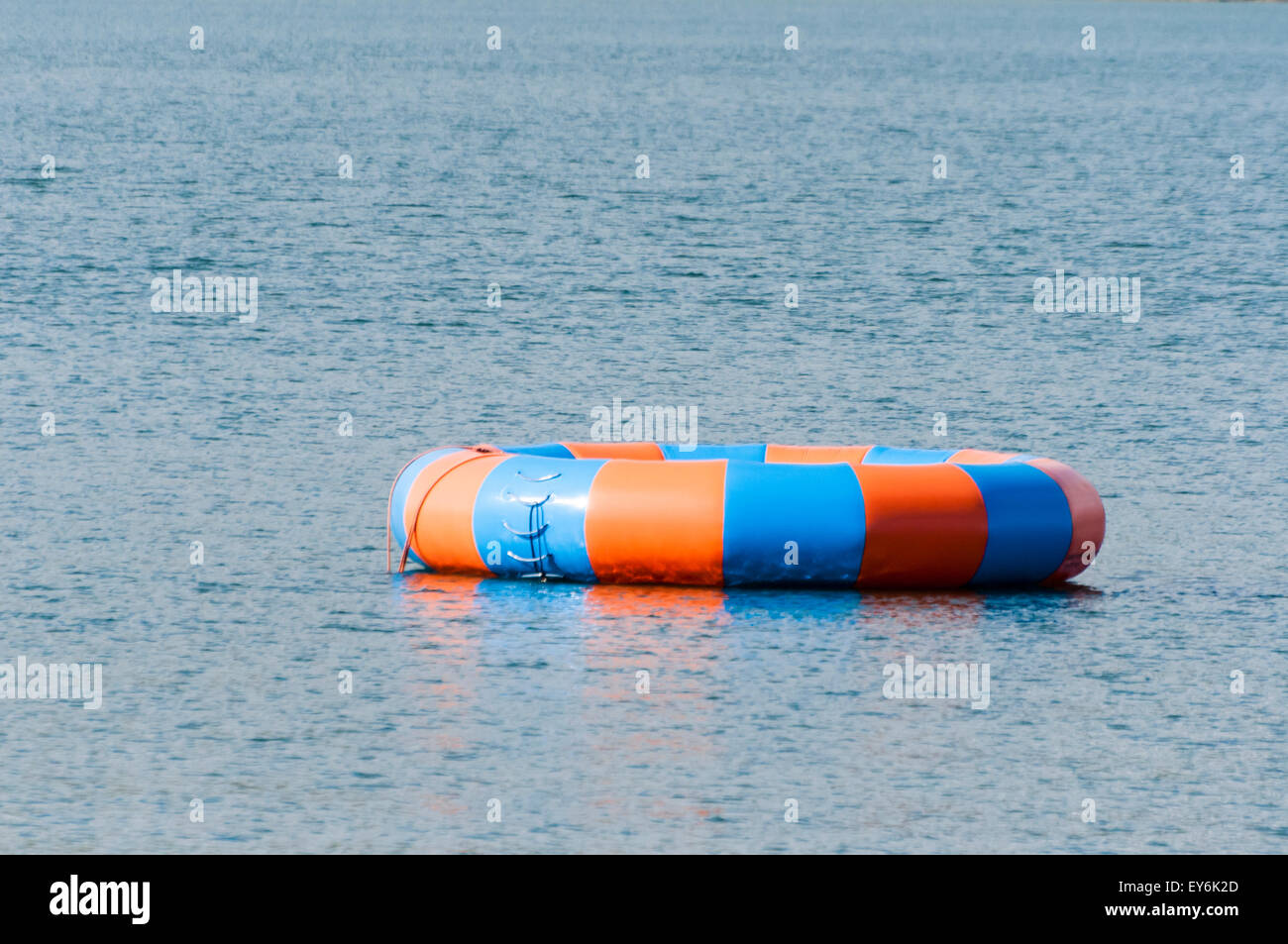 A blue and orange large inflatable ring in the sea at an outdoor activity centre Stock Photo