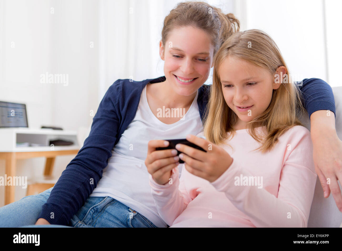 View of a Attractive woman and little sister using mobile Stock Photo