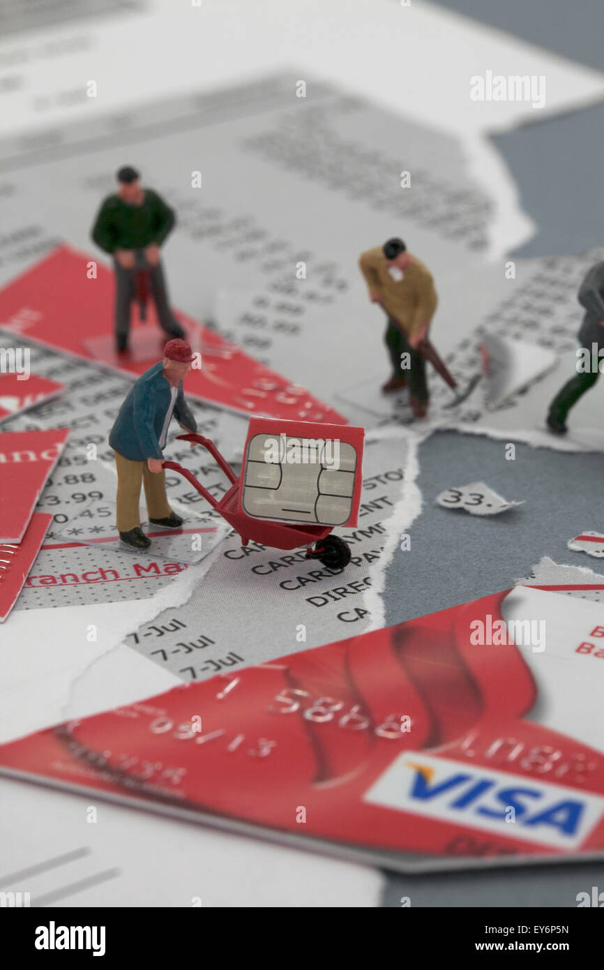 Miniature Workmen Figurines working on torn Bank Statements and cut credit card Stock Photo