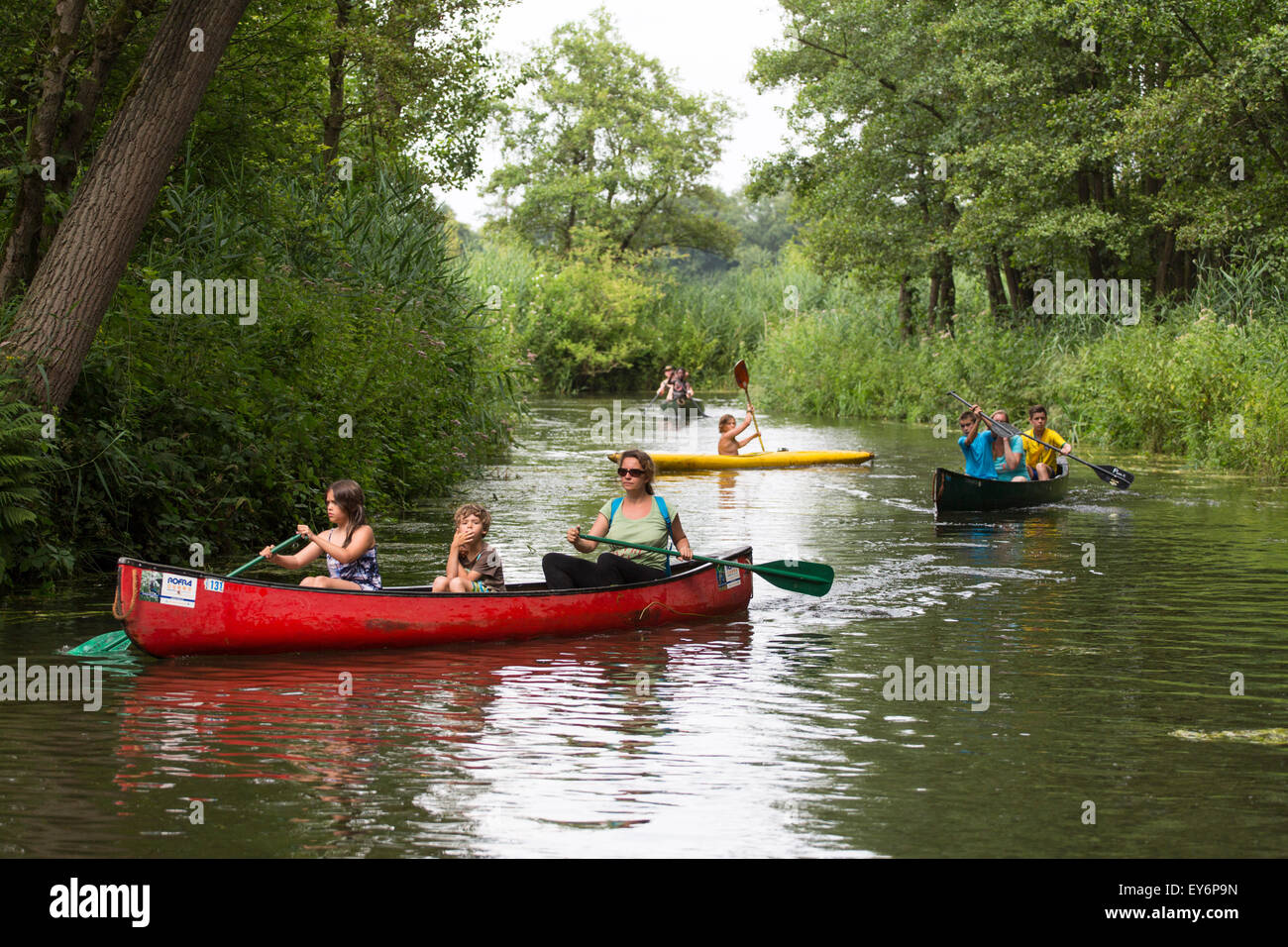 Canoeing family tourists boating at meandering river the 'Dommel' in the Netherlands Stock Photo