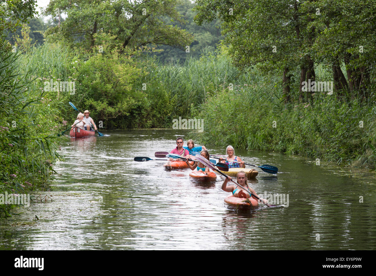 Group of canoeing and kayaking tourists passing at meandering river the 'Dommel' in the Netherlands Stock Photo