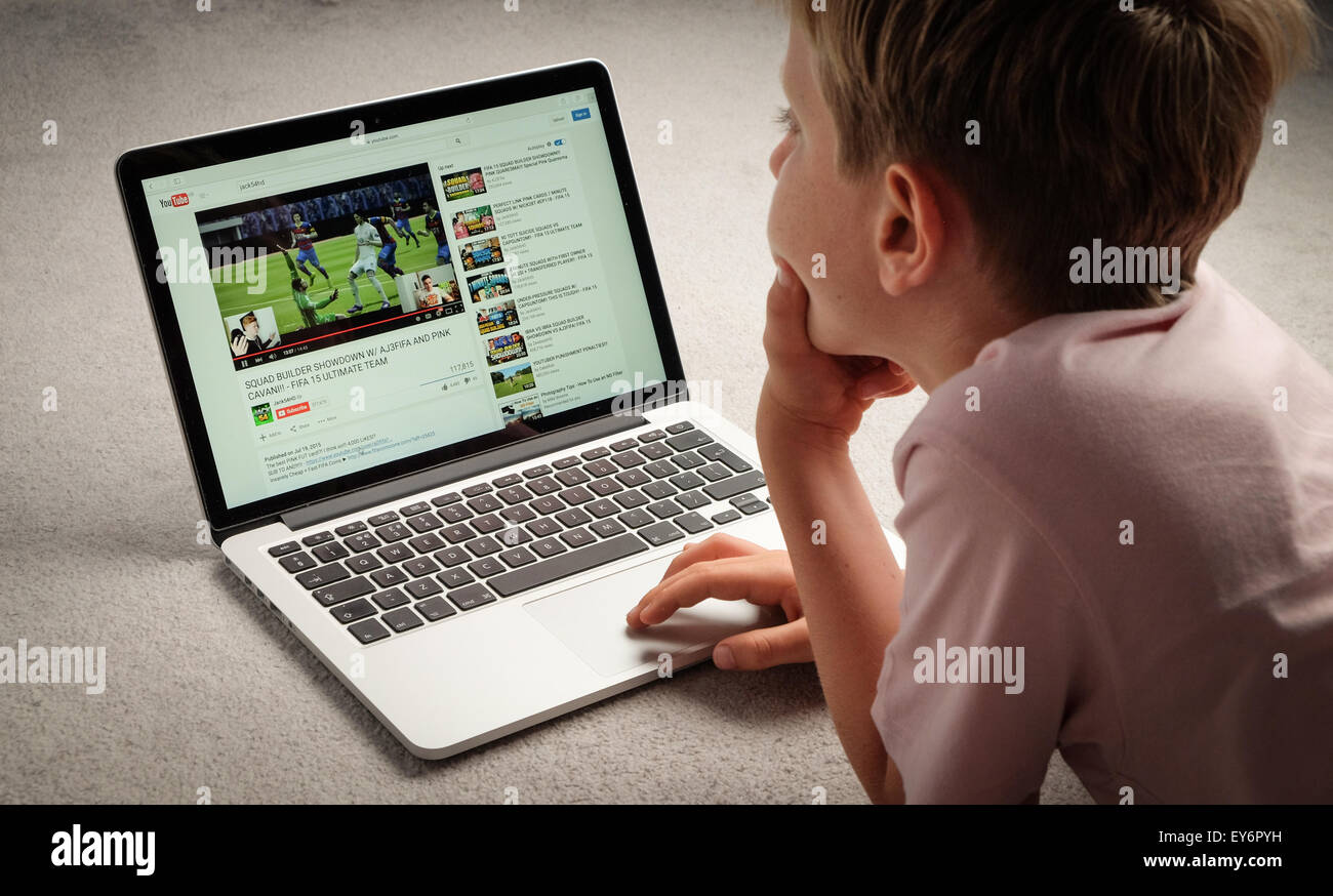 A Child watching Youtube videos on a laptop computer Stock Photo