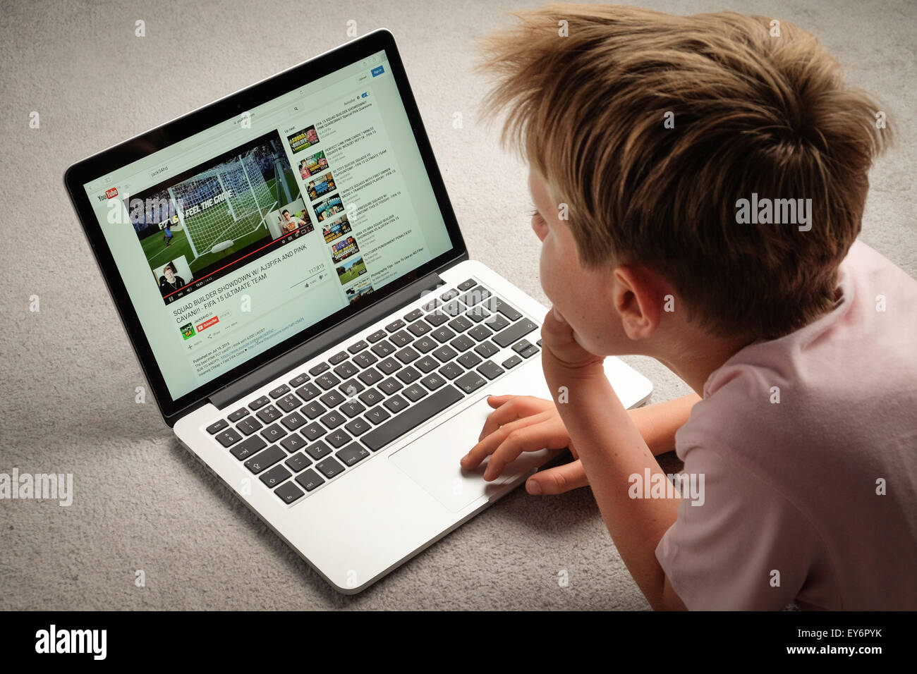 A Child watching Youtube videos on a laptop computer Stock Photo