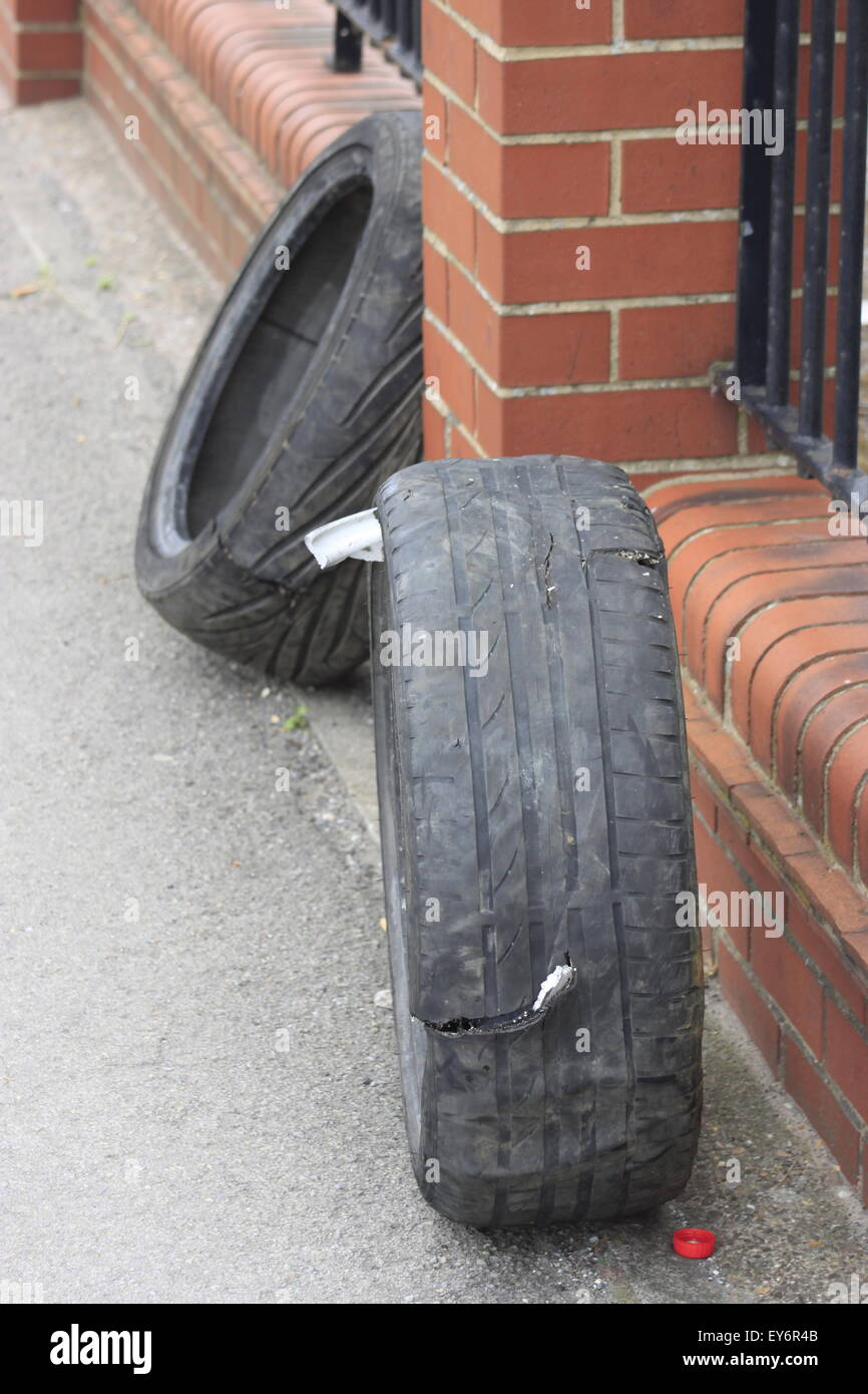 Old worn performance low profile car tyres/tires dumped on urban street in Hull. Worn burned rubber. Shows split/tear in tread. Stock Photo